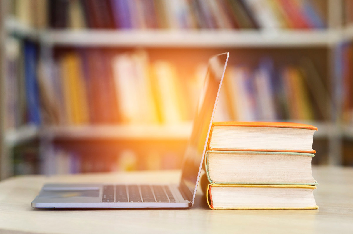 Stack of books and open laptop to show Innovensa's commitment to learning